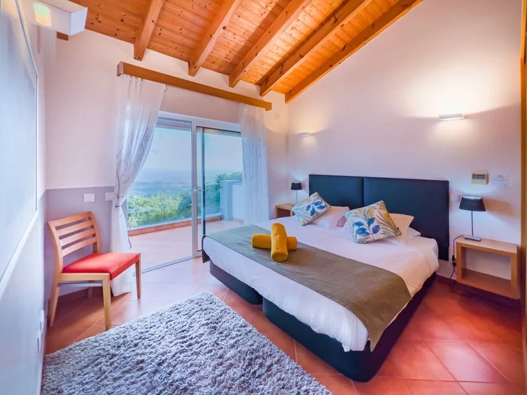 Guest bedroom with timber ceiling and vineyard view
